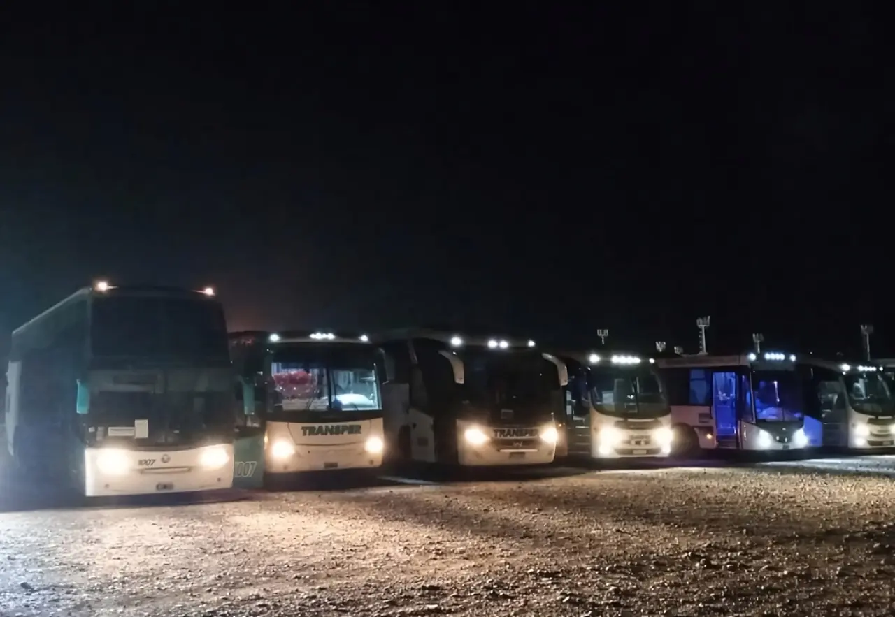 Flota de Transper con las luces encendidas de noche, lista para salir